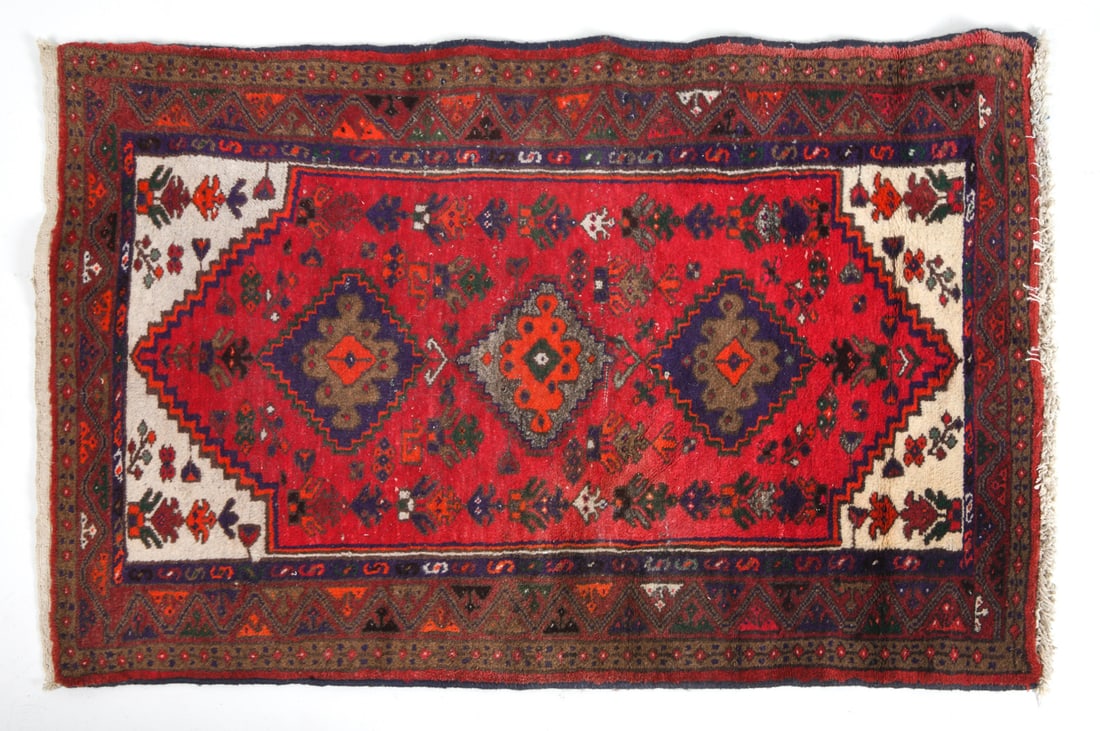 IRANIAN ORIENTAL RUG: Hand-knotted wool with red and blue geometric designs. Iran, 20th century. Tag underneath. Dimensions: L 57" x W 38.5". Condition: Loss to pile in center. Slight Fading.