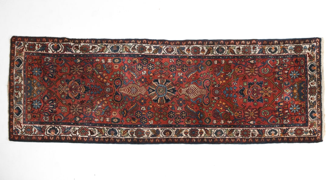 PERSIAN ORIENTAL RUNNER RUG: Hand-knotted wool rug with geometric and floral designs. 20th century. Dimensions: L 120" x W 39.5". Condition: Slight discoloration to fringe, overall presents well.