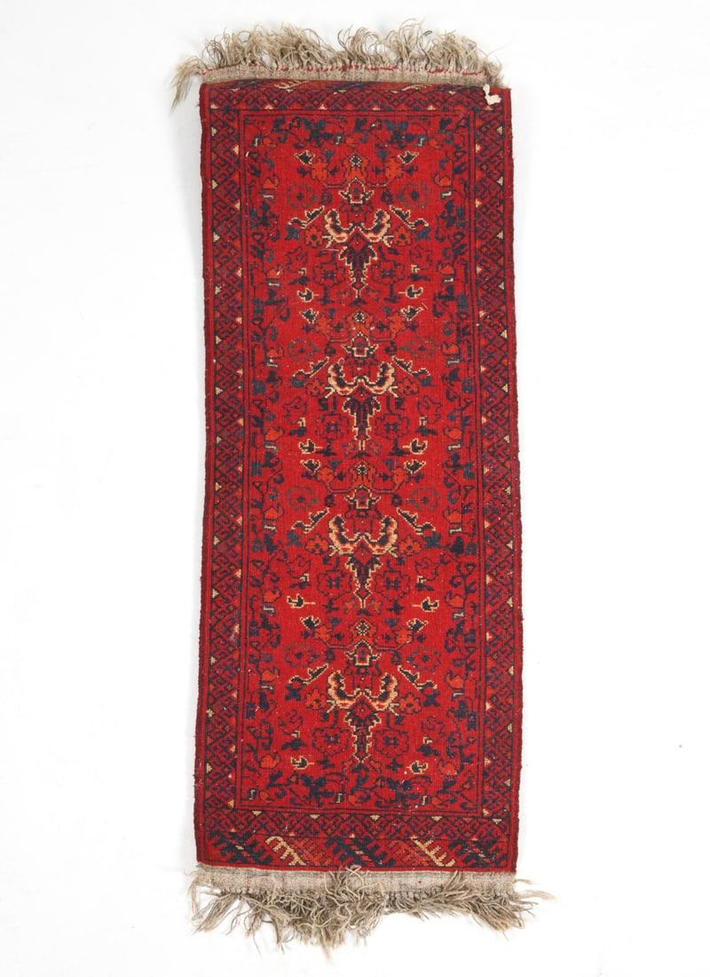 PERSIAN ORIENTAL RUNNER RUG: Hand-knotted wool rug with red geometric designs. 20th century. Dimensions: L 60'' x W 20". Condition: Minor losses and sun fading on fringe. Slightly stiff. Wear consistent with age and use.