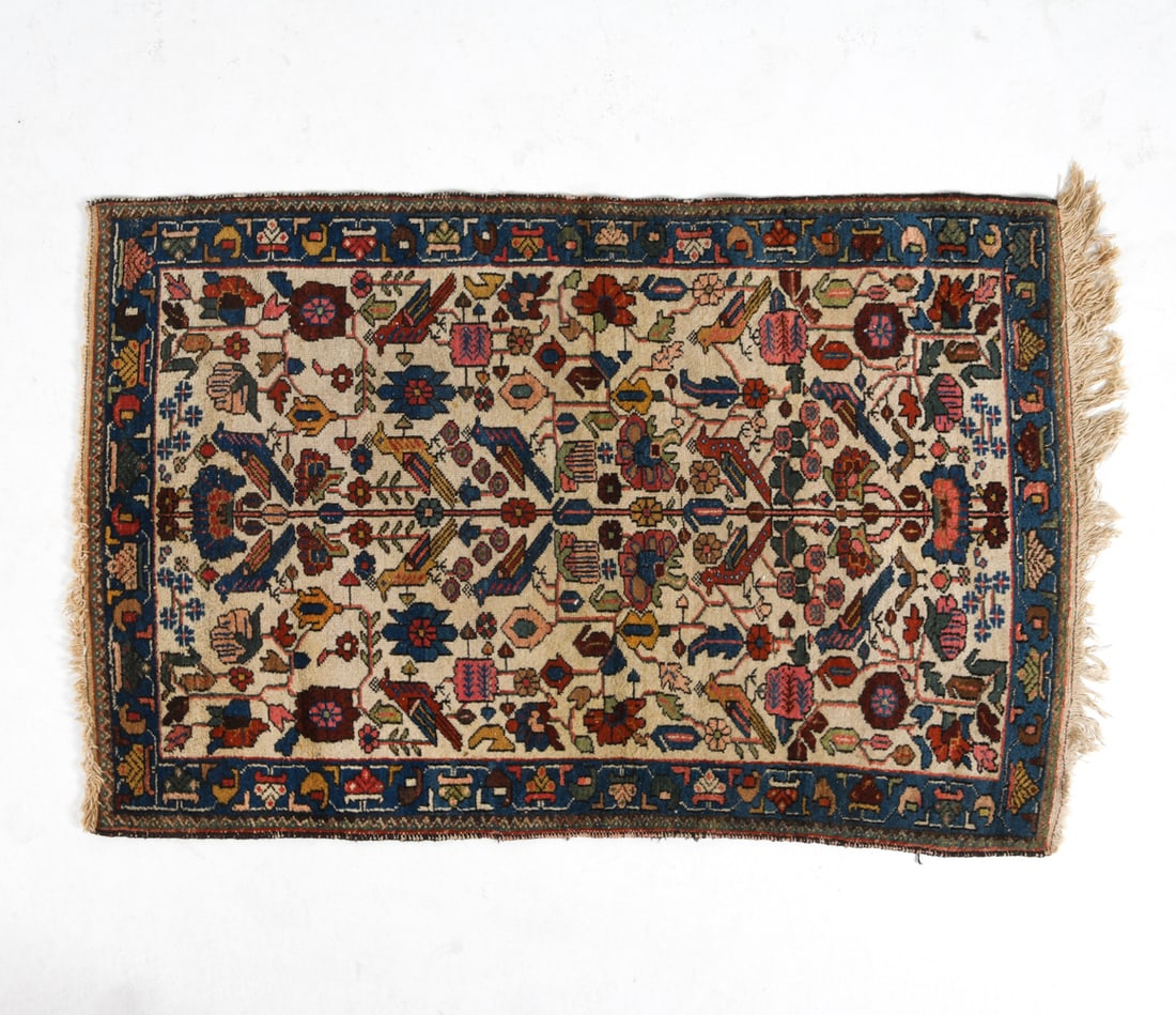 ORIENTAL RUG: Hand-knotted oriental rug with cream and blue floral design. 20th century. Dimensions: L 53" x W 34". Condition: Losses and discoloration to fringe. Losses to border.