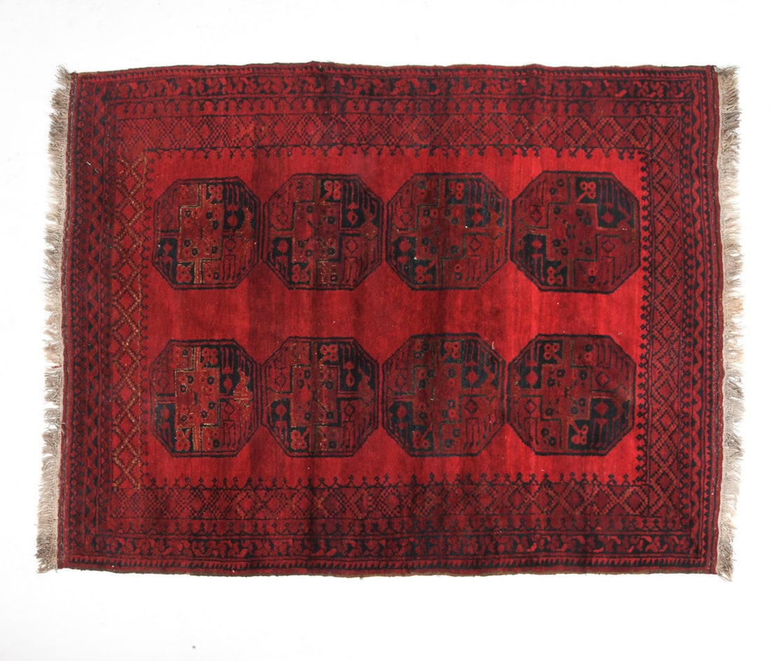 AFGHAN ORIENTAL RUG: Hand-knotted wool right in red and black octagonal 'gul' designs. 20th century. Dimensions : L 88" x W 66". Condition: Minor Fading, may need cleaning. Wear consistent with age and use.