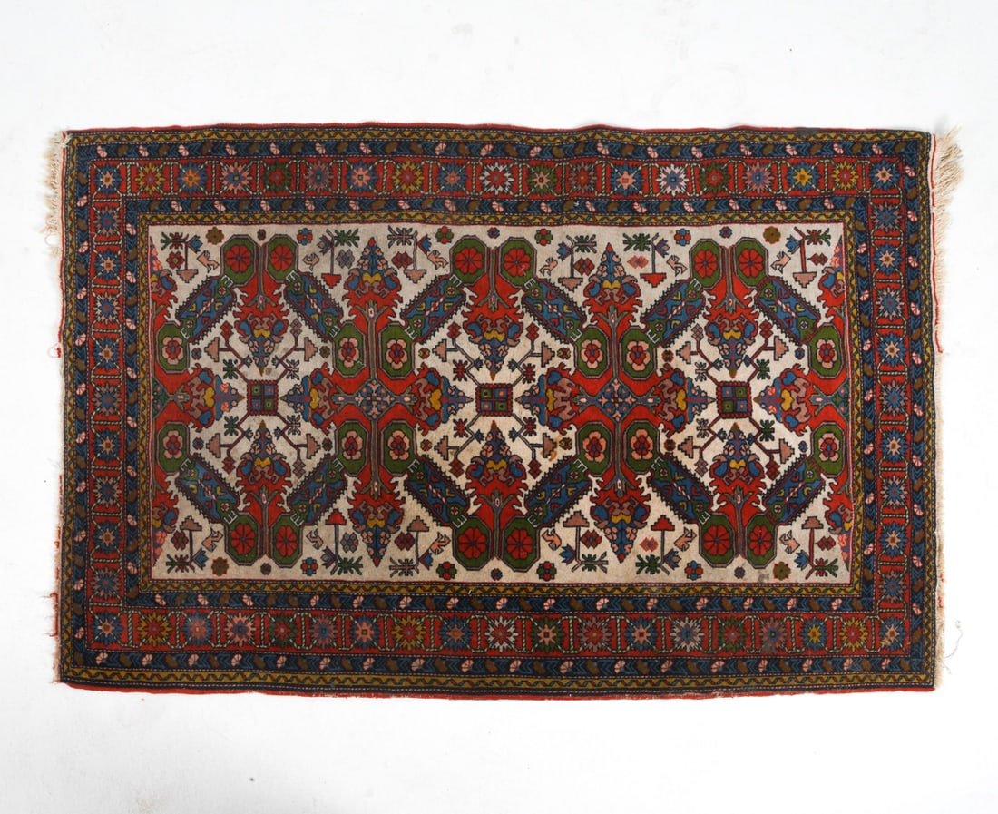 ORIENTAL RUG: Hand-knotted oriental rug in red, beige, and blue geometric designs. 20th century. Dimensions: L 80" x W 50". Condition: Few losses to border and fringe. Discoloration and staining. Needs cleaning.