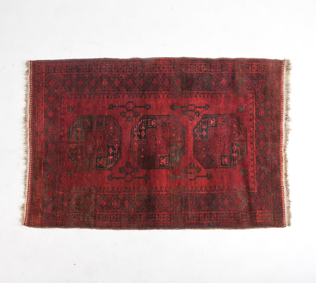 AFGHAN ORIENTAL RUG: Hand-knotted wool rug with octagonal elephant footsteps or 'gul' pattern. 20th century. Dimensions: L 72" x W 47". Condition: Minor sun fading. Loss to fringe. Wear consistent with age and use .