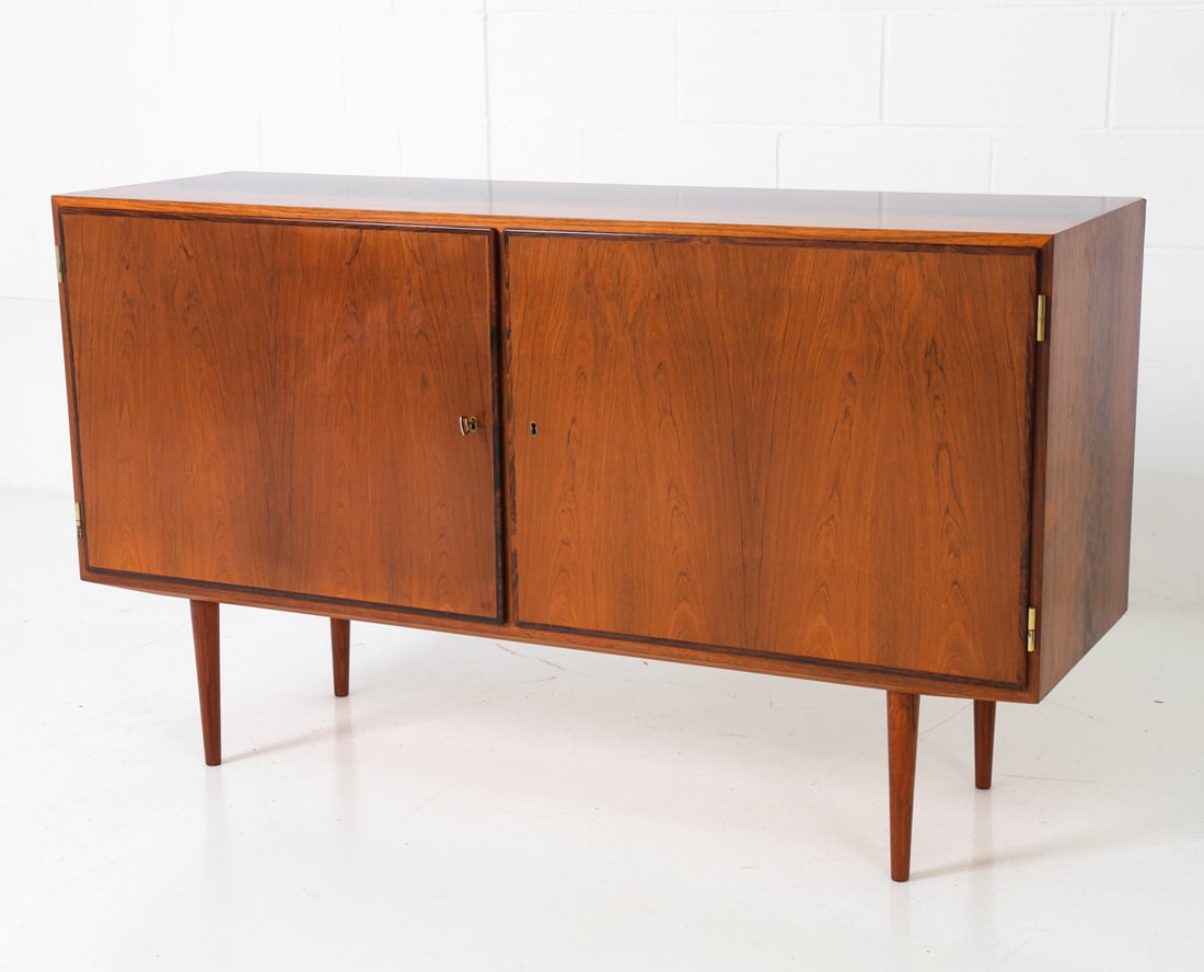 CARLO JENSEN HUNDEVAD DANISH ROSEWOOD SIDEBOARD: A key included. Stamped on the backside. Denmark, circa 1960s. Dimensions: H 32" x W 55" x D 17" Condition: Overall presents well. Wear consistent with age and use.