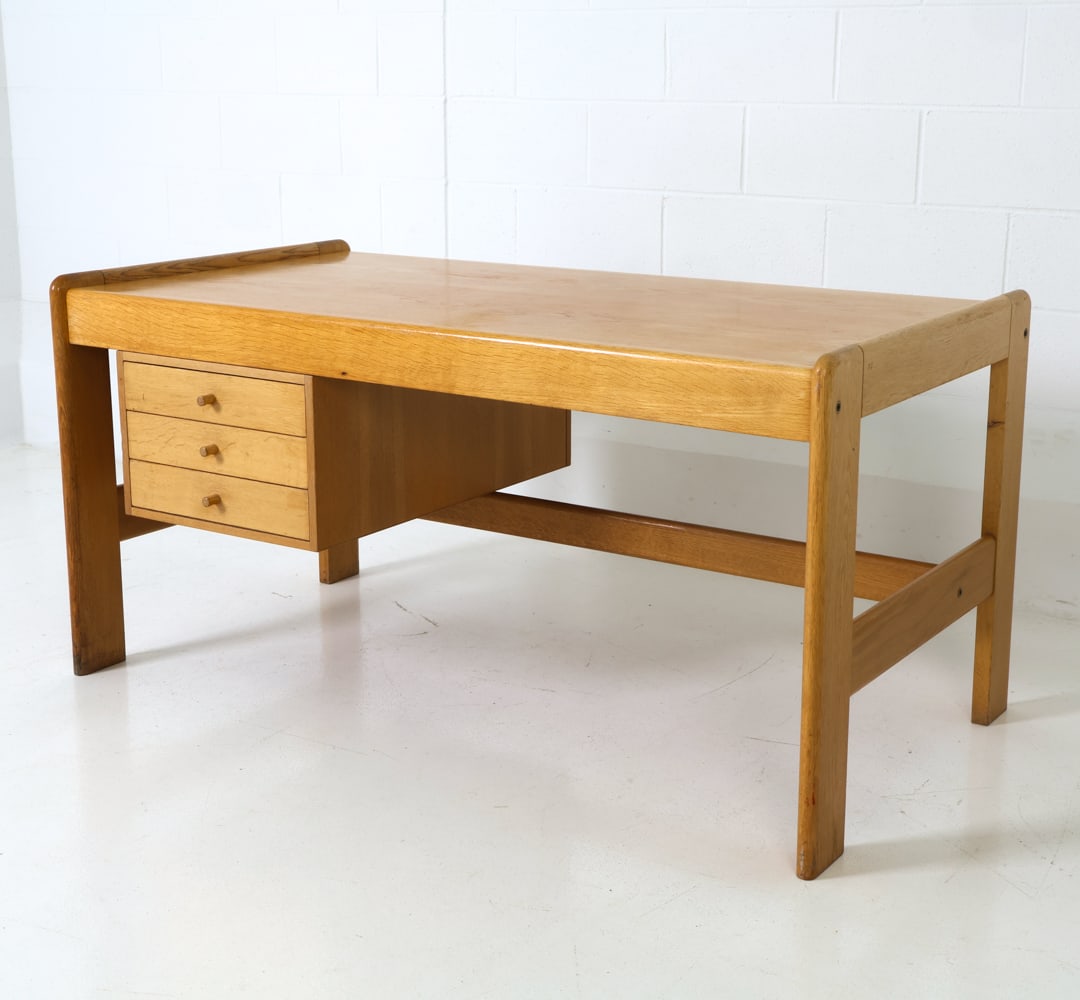 WEGNER STYLE DANISH OAK WRITING DESK C. 1970S: Oak frame desk with three drawers. Flat-profile side with rounded edges. Denmark, circa 1970s. Dimensions: H 29" x W 59" x D 31" Condition: Sun-fading to top, scratches and rubs to top, Wear
