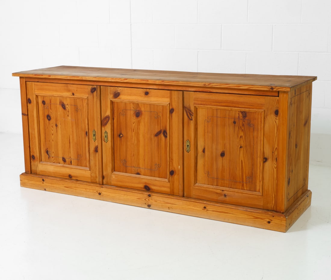 DANISH PINE SIDEBOARD C. 1970S: Pine frame with fluted carving on the surface. Denmark, circa 1970s. Sits freely on base. Dimensions: H 33" x W 71" x D 20" Condition: No key included. Some scratches, scuffs, and dings. Wear