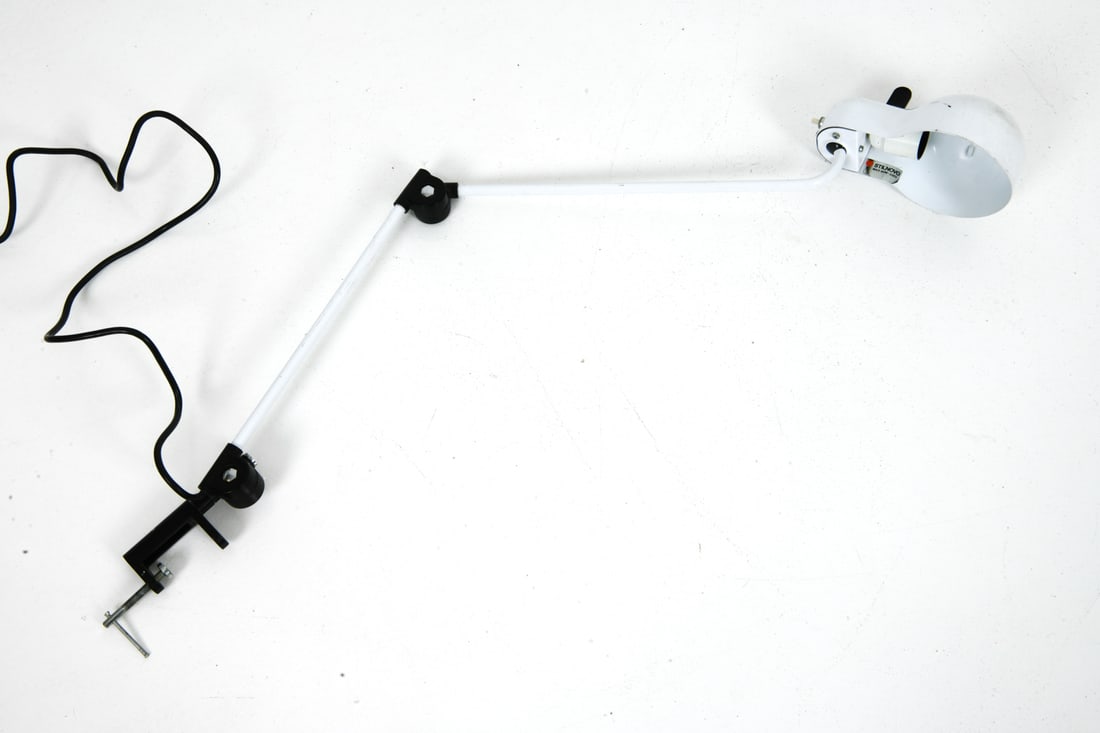 STILNOVO ITALIAN ADJUSTABLE DESK LAMP: Desk lamp that clips to the edge of a desk that pivots at the base and neck. Labeled near socket. Dimensions: H 24.25" x W 5.25" x D 12.5" Conditions: Not tested, cord cut. Wear consistent with age an