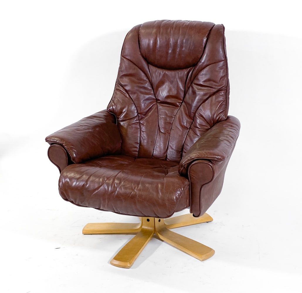 SKOGHAUG LEATHER LOUNGE CHAIR C. 1970S: Brown leather lounge swivel chair. Beech bentwood legs. Tagged "Skoghaug Industries" to metal frame underneath. Norway, circa 1970s. Dimensions: Chair H 42" x W 32" x D 26" x SH 16.25". Condition: Min