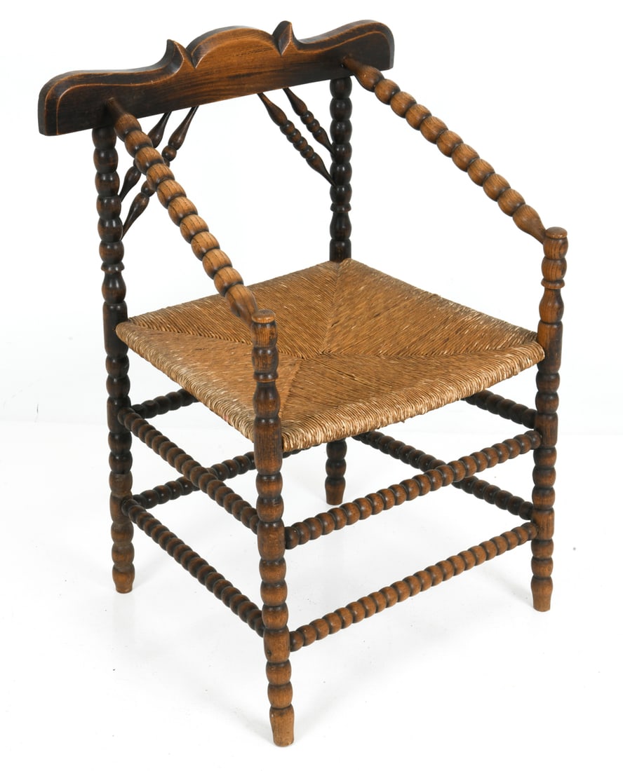 ART DECO DUTCH OAK & RUSH CHAIR C. 1920S: Arts and craft style bobbin-turned chair with rush seat. Netherlands, circa 1920s. Dimensions: H 34" x W 24.5" x D 18.5" x SH 18" Condition: Sun fading and patina to frame, rubbing to seat. Wear consi