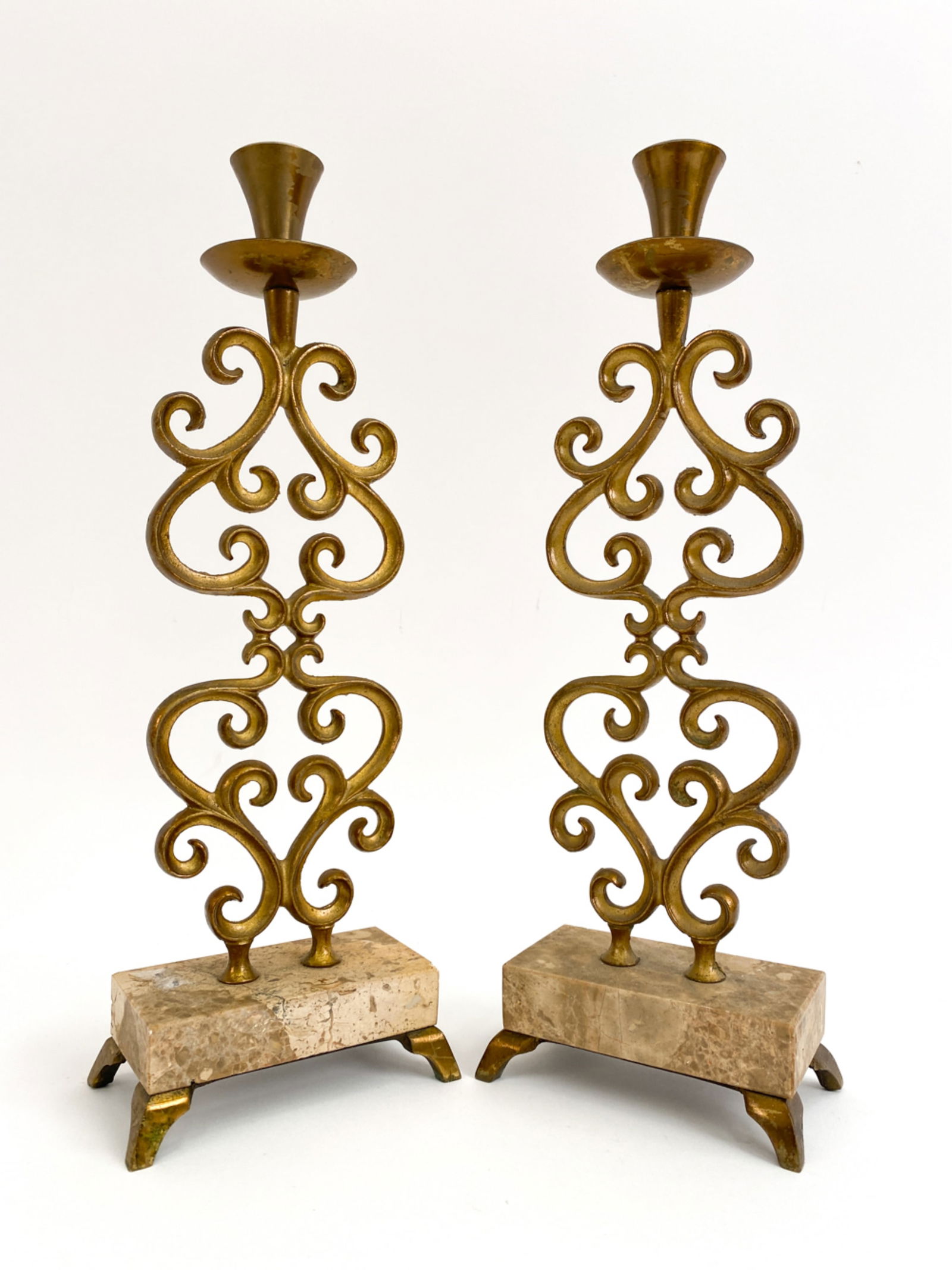 PAIR OF MID-CENTURY ISRAELI CANDLESTICKS: Pair of brass and travertine candlesticks. Marked underneath, made in Israel. Dimensions: H 12.5" x W 4.5" x D 2.5" Condition: Tarnish to brass. Corner chip to one travertine and couple pinpoint nicks