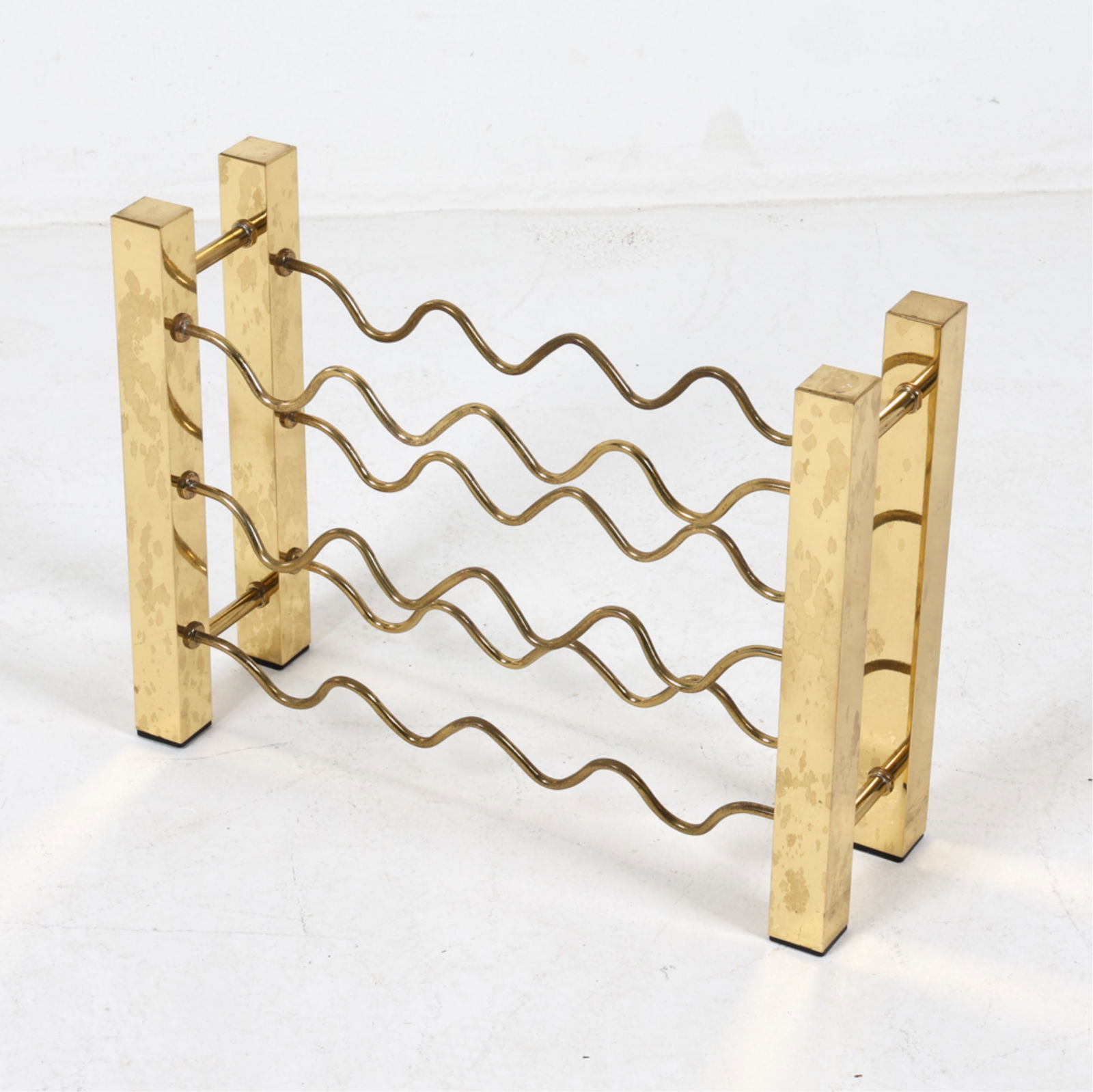 HOLLYWOOD REGENCY STYLE BRASS WINE RACK, C.1980'S: Dimensions: H 16" x W 21.5" x D 6.75". Condition: Some scuffs and scratches to brass finish. Wear consistent with age and use.