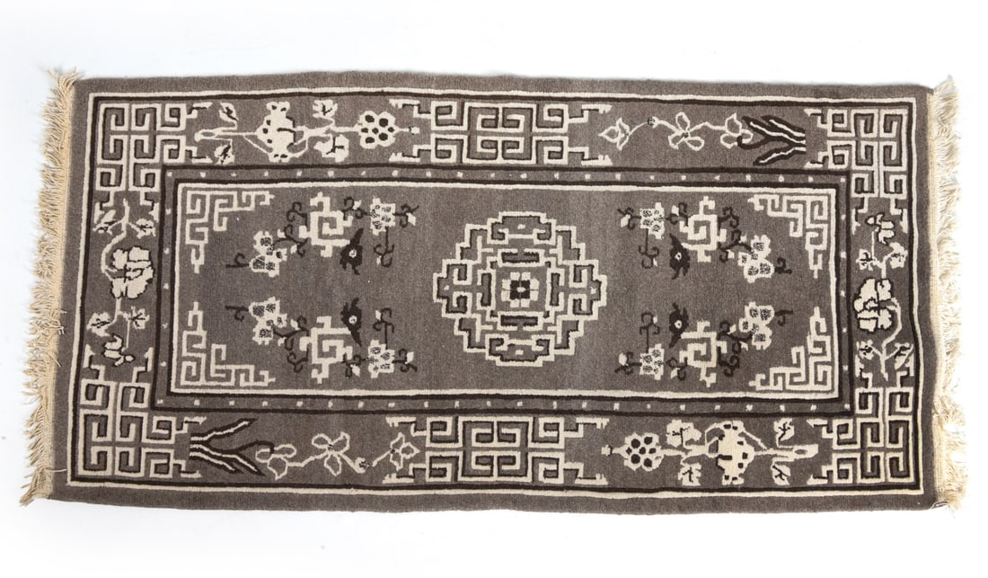 20TH CENTURY ORIENTAL RUG: Hand knotted Oriental style rug in grey with geometric motifs. 20th century. Dimensions: L 77" x W 36". Condition: Overall presents well, slight discoloration to fringe.