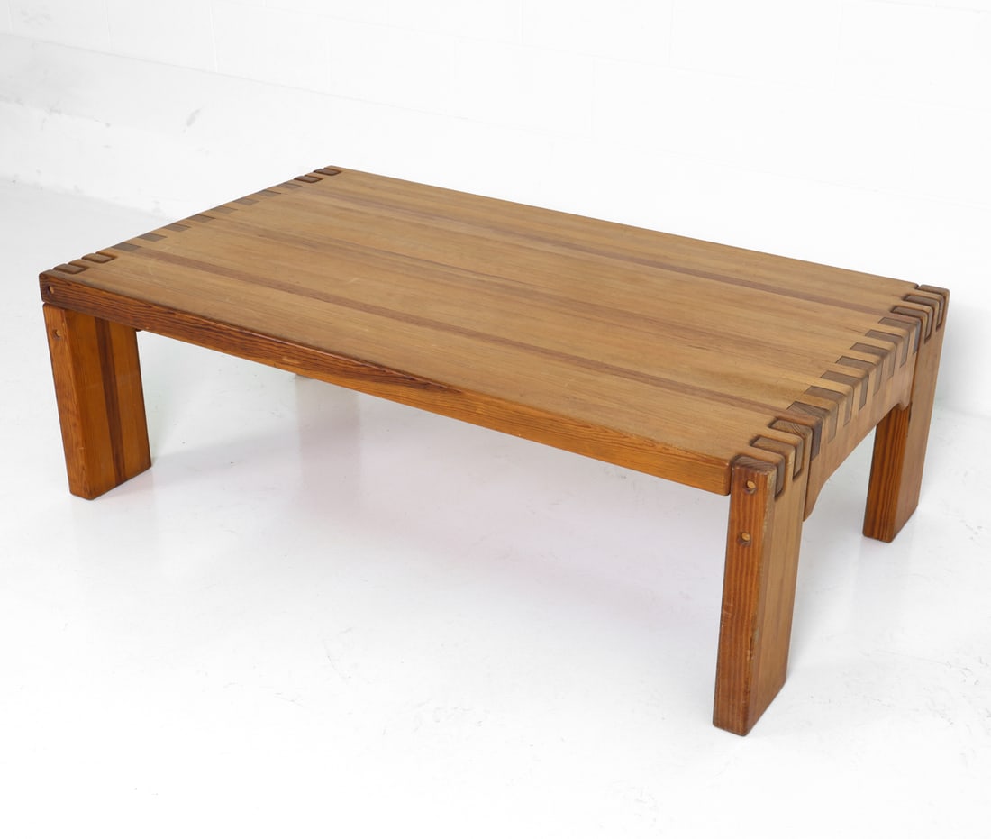 BRUTALIST DANISH PINE DOVETAIL COFFEE TABLE 1970S: In solid pine blocks joined together. Denmark, circa 1970's. Dimensions: H 17.5" x W 55" x D 32.75" Condition: Minor stress cracks, scuffs, rubs to top and legs, some surface-level gouges to one side.