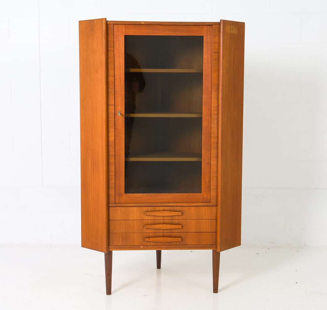 P. RIMMES DANISH TEAK & GLASS CORNER CABINET 1970S: Includes a key. Glass door with interior shelving. Three drawers on the lower sections. Apparently unmarked. Denmark, circa 1970s. Dimensions: H 57.25" x W 25" x D 22.25" Condition: Wear consistent wi