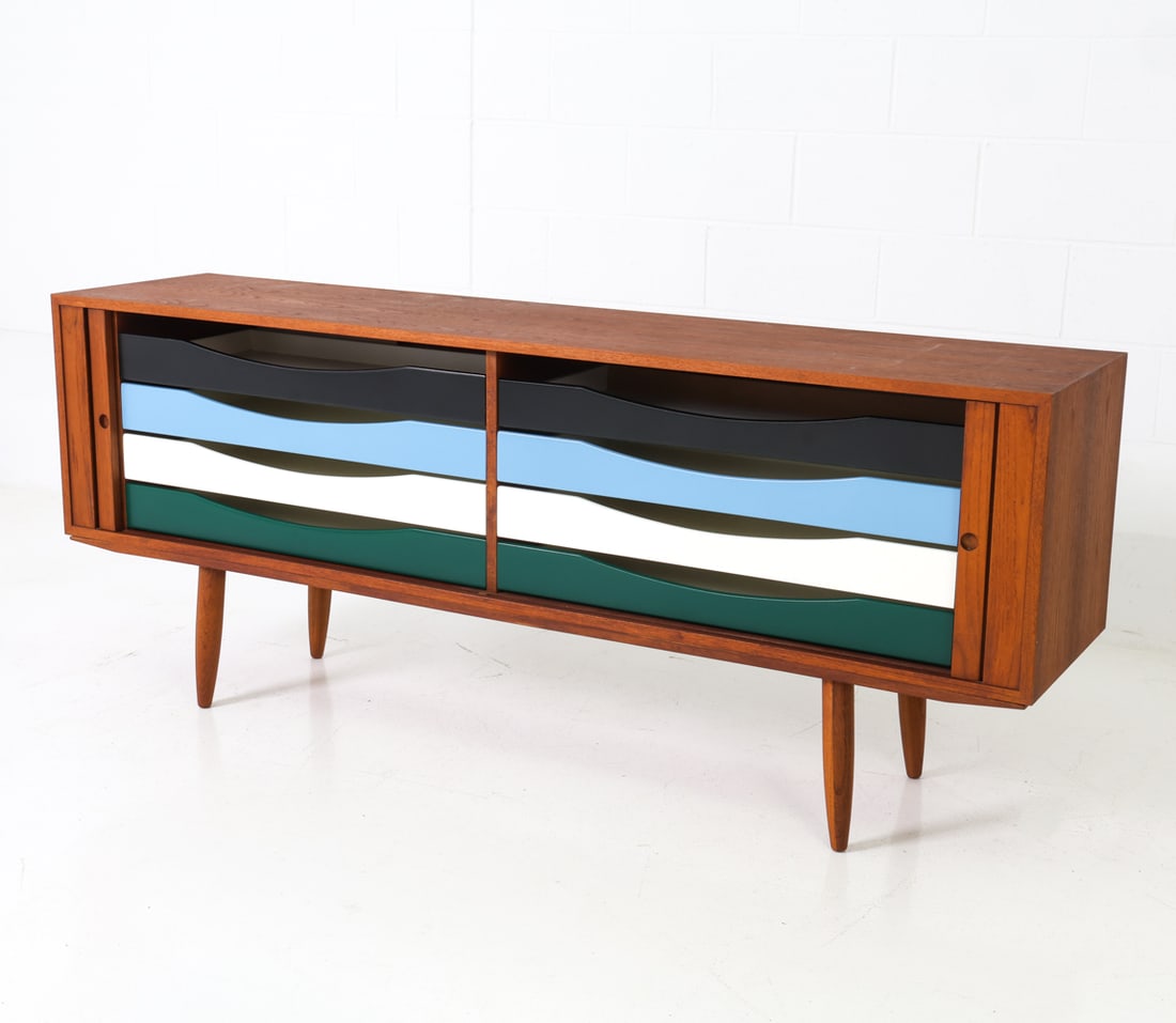 BRUNO HANSEN FOR J&P DESIGN DANISH TEAK SIDEBOARD: Teak frame with tambour doors, inset circular pulls, and eight wide drawers in four colors. Apparently unmarked. Denmark. Dimensions: H 29" x W 70.75" x D 16.5" Condition: Doors slightly sticking,