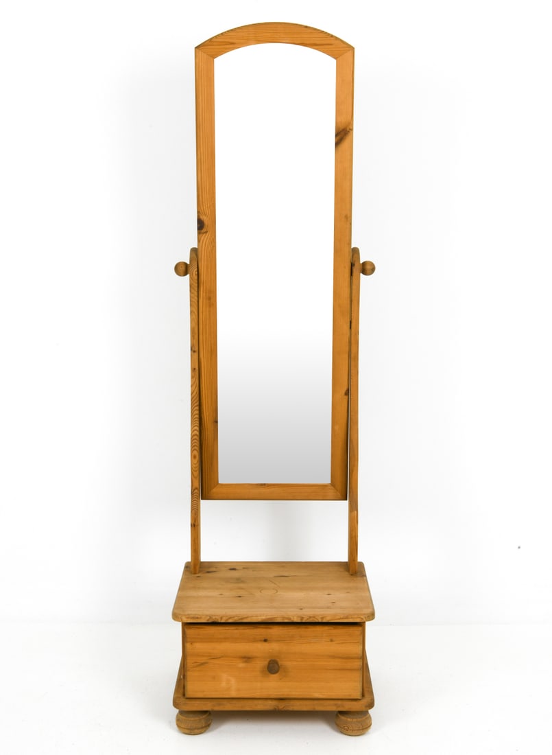 SWEDISH PINE CHEVAL MIRROR WITH CHEST C. 1970S: Standing cheval mirror made from pine, able to tilt, with attached one drawer chest as the base. Apparently unmarked. Dimensions: H 62.5" x W 18" x D 14.75" Condition: Light surface marks and water ri