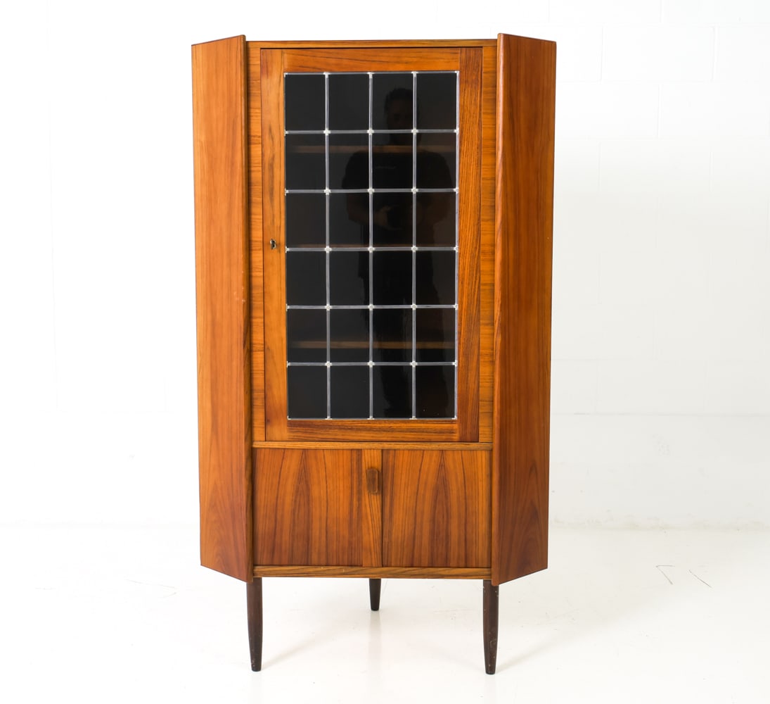 VALENTINSEN STYLE DANISH ROSEWOOD CORNER CABINET: Includes a key. Rosewood cabinet with glass front door in rectangular-shaped details. Denmark, circa 1970's. Dimensions: H 61" x W 35" x D 23" Condition: Wear consistent with age and use. Few minor sc