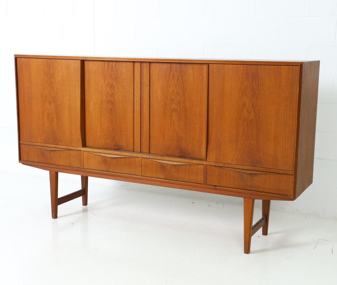 E. W. BACH FOR SEJLING DANISH TEAK SIDEBOARD 1960S: For Sejling Skabe. Four sliding doors and drawers with sculpted handles. Shelves and mirrored back with two drawers inside. Apparently unmarked. Care tag to back. Denmark, circa 1960's. Dimensions: H