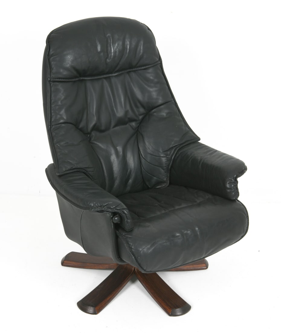 HJORT KNUDSEN DANISH LEATHER ARMCHAIR C. 1970S: Model "Genova" swivel armchair. Black leather upholstery with stained walnut base. Apparently unmarked. Denmark, circa 1970s. Dimensions: H 39.75" x W 30" x D 31" x Sh 16.25" Condition: Faint rubs and