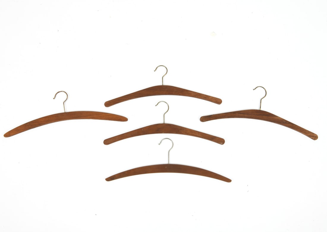 VINTAGE DANISH TEAK COAT HANGERS: Grouping of (5) teak hangers. Dimensions: H 6.75" x W 17.5" Condition: Wear consistent with age and use including light surface wear. Oxidation to hooks. 83