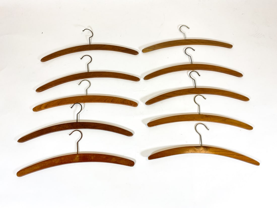 DANISH TEAK COAT HANGERS GROUPING C. 1960S: (10) Teak hangers with metal hooks. Denmark, circa 1960s. Dimensions: H 5" x W 17.5". Condition: Minor scuffs and rubs, wear consistent with age and use.