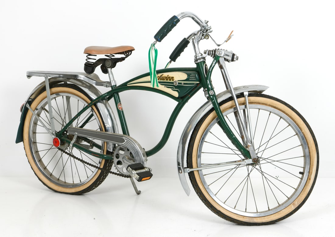 VINTAGE SCHWINN CHILDS BICYCLE C. 1950S: Curved frame, fenders, and a rear rack in green and ivory color with pinstripe details. Marked on the frame. Circa 1950s. Dimensions: H 30" x W 54" x D 18.5" Condition: Wear consistent with age and us
