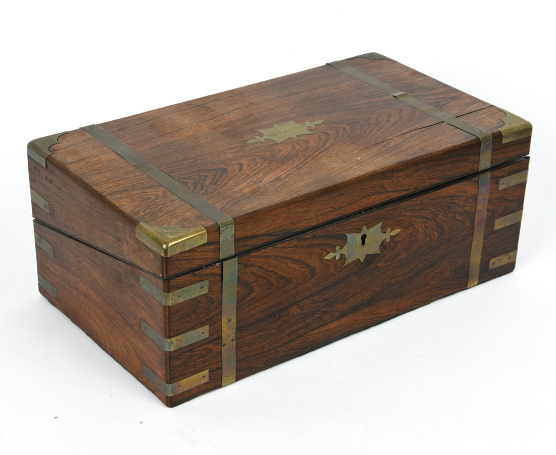 19TH C. ANTIQUE LAP DESK: Portable desk or writing slope. Felt-lined writing surface interior and storage compartments for writing materials. Lid with name engraved. Brass escutcheons and banding on the edges. 19th century. Di