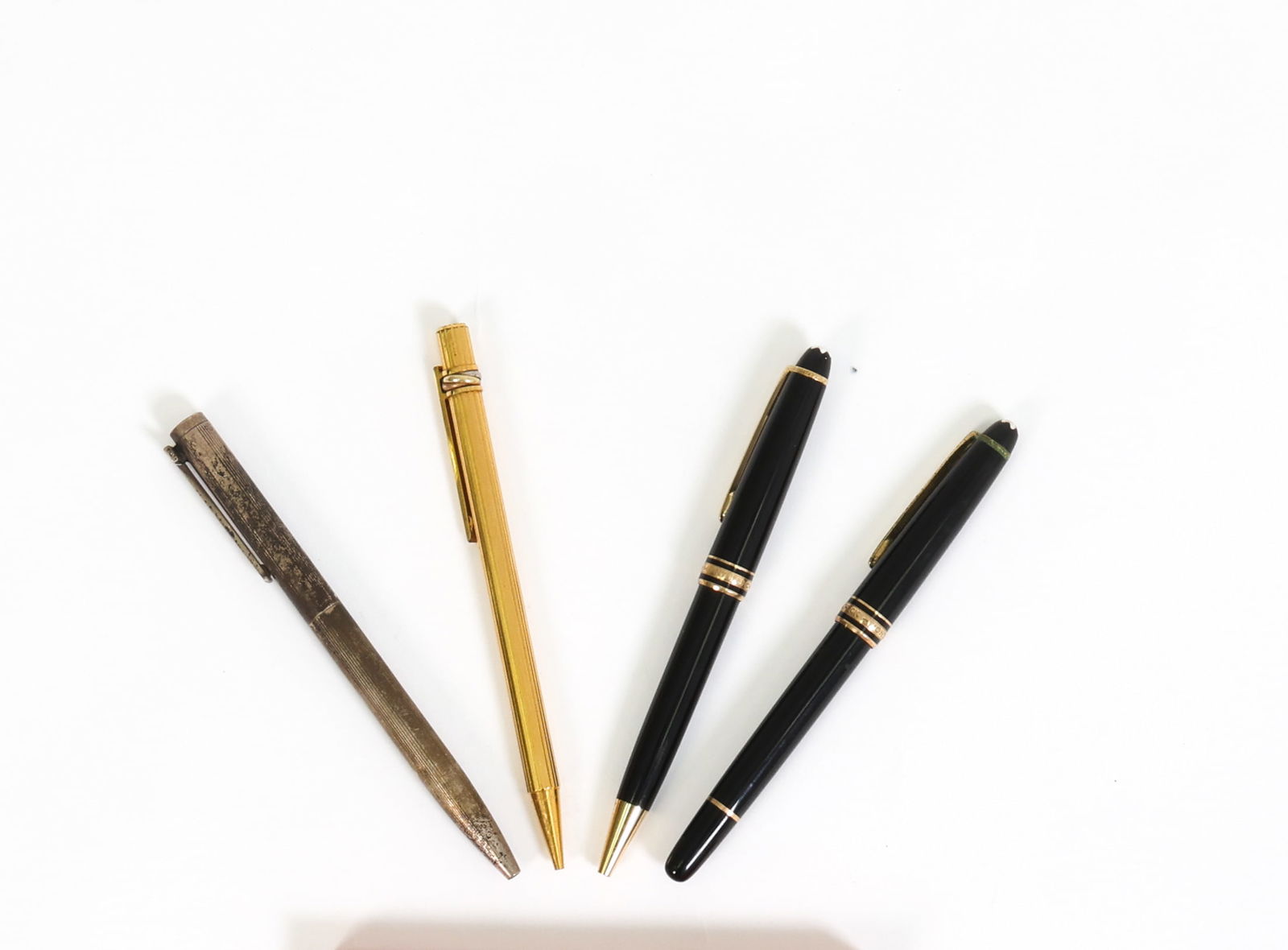 (4) VINTAGE INK PEN GROUPING: (4) Vintage pens including Montblanc & Cartier. Gold plated pen engraved "Must De Cartier" Black pens engraved "Montblanc Meisterstuck". One silver plated pen. Dimensions: (Largest) H 5.25"
