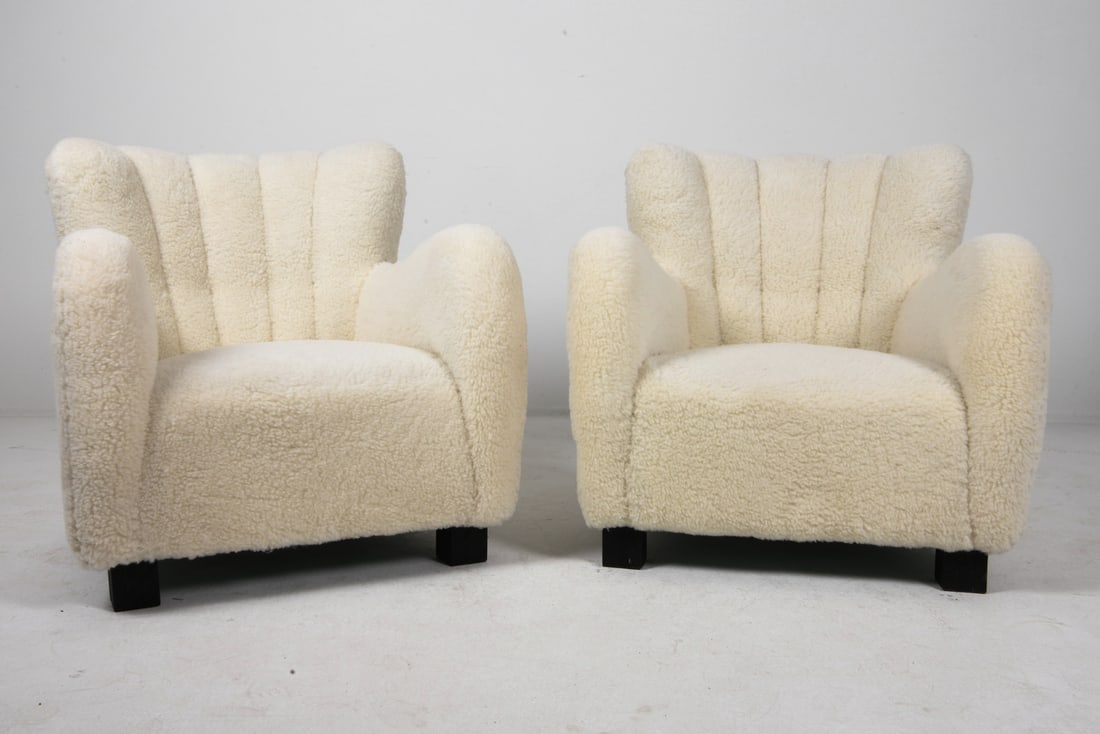 PAIR LASSEN STYLE DANISH LAMBSWOOL LOUNGE CHAIRS: White lambswool upholstery with channel backs. Oak legs. Denmark, circa 1960s. Dimensions: H 32" x W 27.5" x D 29" x SH 16.5". Condition: Scratches and rubs to feet, wear consistent with age and use.