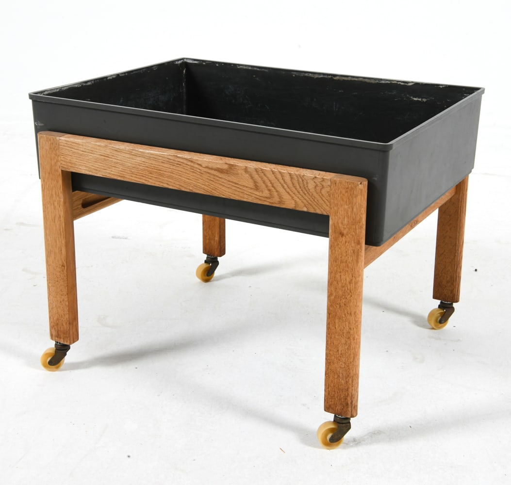 DANISH OAK PLANTER C. 1970S: Oak legs with plastic tray. Denmark, circa 1970s. Dimensions: H 15" x W 19.5" x D 16". Condition: Wear consistent with age and use.