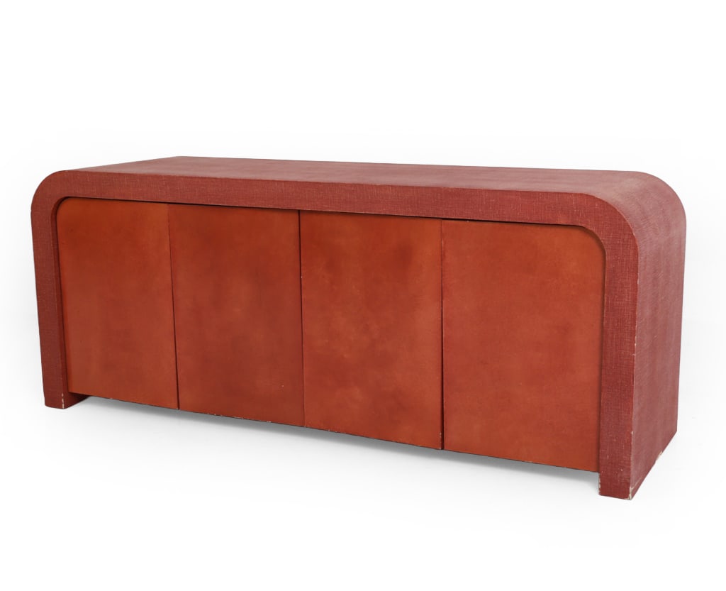 MANNER OF SPRINGER LINEN WRAPPED SIDEBOARD: Sculptural rounded waterfall credenza or sideboard by Minic Custom Woodwork, New York. Textured fabric-wrapped finish to top and side surface. Labeled to the interior left top. Late 20th century. Dime