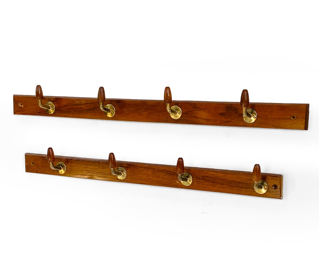 PAIR OF DANISH TEAK COAT RACKS C. 1960S: (2) Teak coat racks with brass hooks. Denmark, circa 1960s. Dimensions: H 2.5" x W 28.5" x D 2.5". Condition: Scuffs and scratches, some white paint marks. Wear consistent with age and use.
