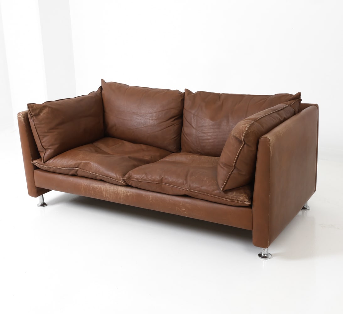 ERIK JORGENSEN STYLE DANISH LEATHER LOVESEAT 1970S: Metal legs and cognac leather upholstered two seater sofa. Apparently unmarked. Denmark, circa 1970's. Dimensions: H 24.5" x W 63" x D 32" x SH 14" Condition: Wear consistent with age and use. Some di