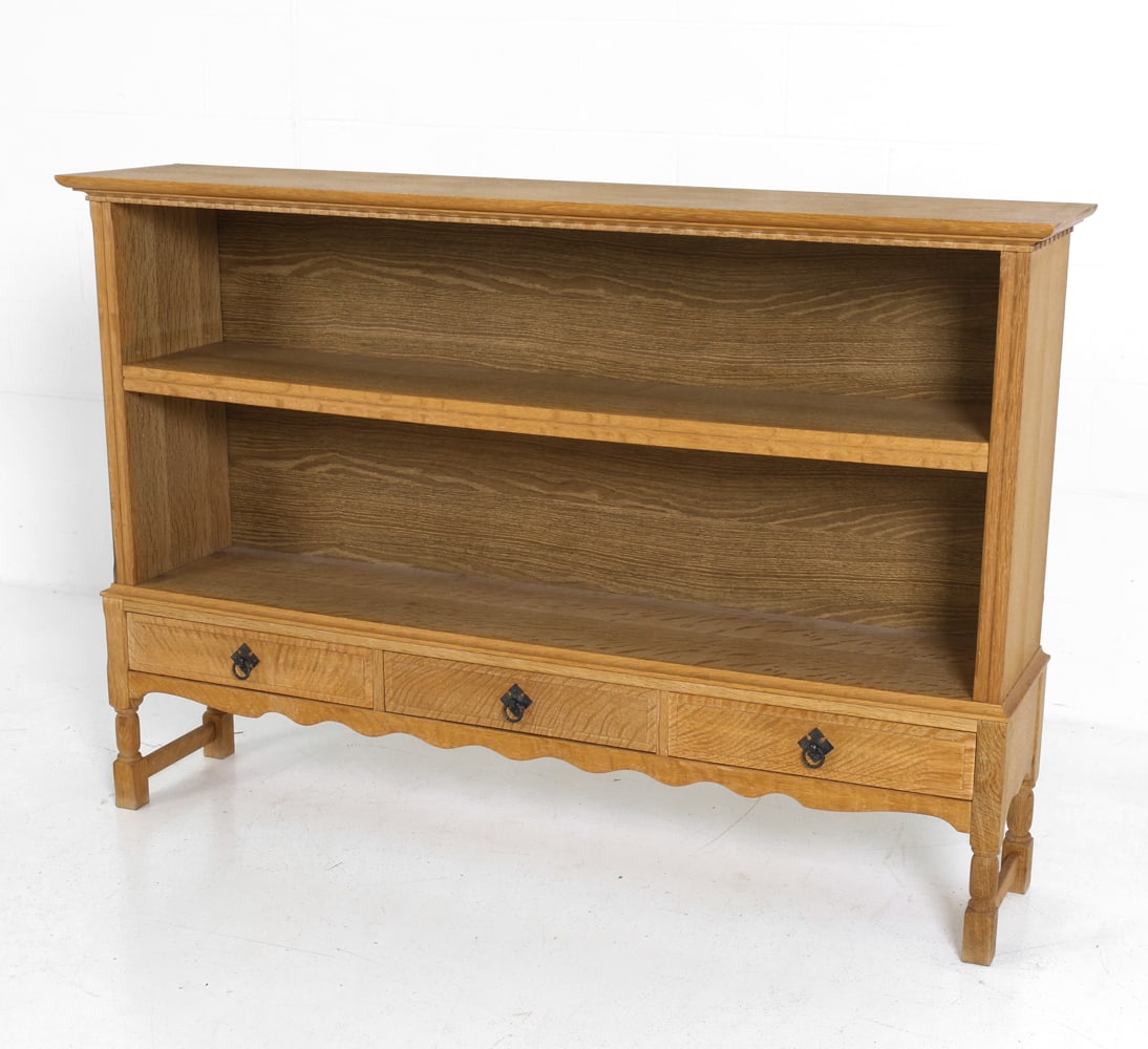STYLE OF KJAERNULF DANISH OAK BOOKSHELF C. 1970S: Three drawers with brass pulls and one adjustable shelf. Denmark, circa 1970's. Dimensions: H 38.75" x W 56.75" x D 12.25" Condition: Rubs, nicks to top and edges. Wear consistent with age and use.