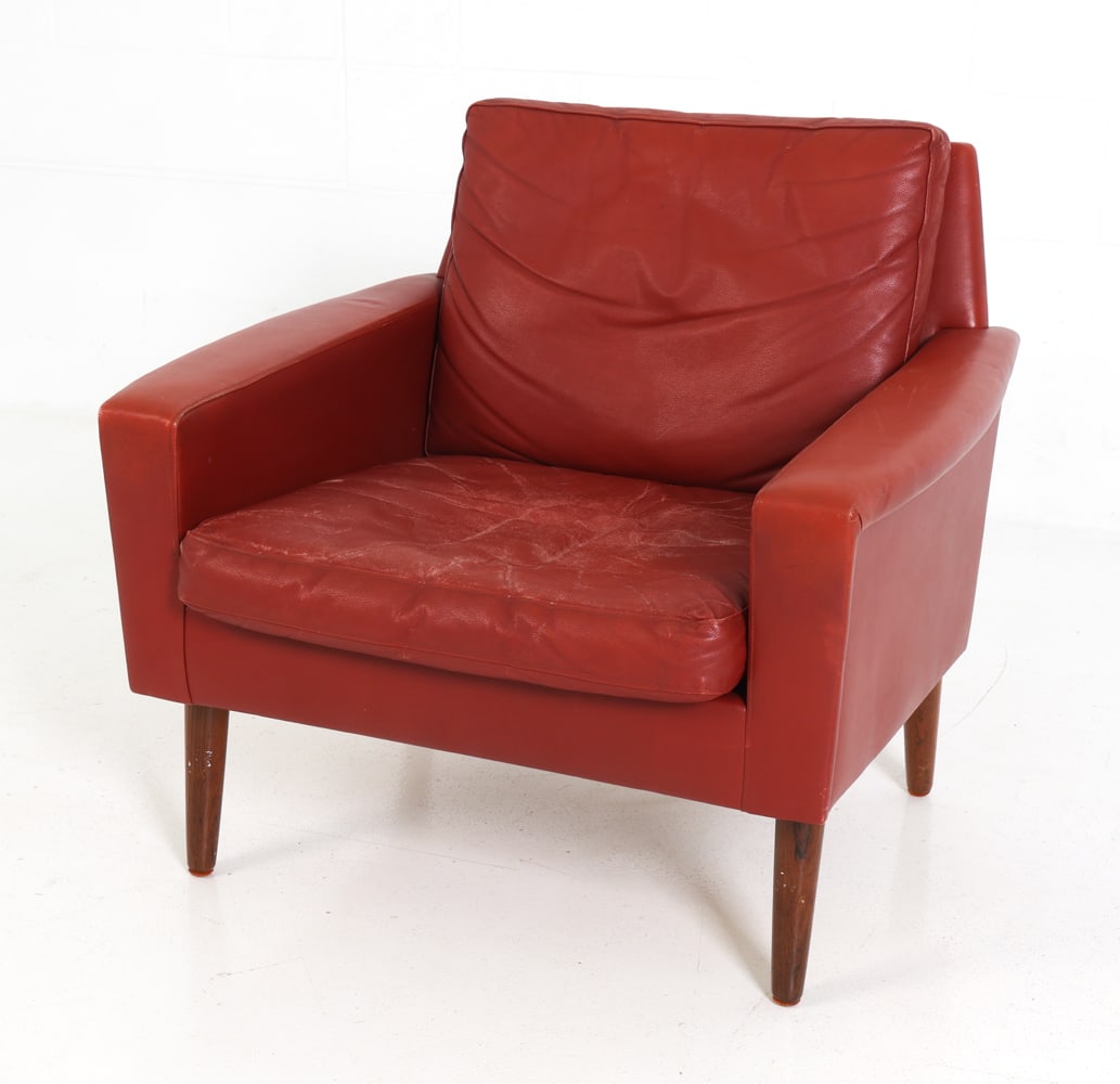 STYLE OF OSTERVIG DANISH LEATHER ARMCHAIR 1960S: Danish lounge chair with red leather upholstery and teak legs. Denmark, circa 1960's. Dimensions: H 27" x W 30" x D 27" x SH 16" Condition: Wear consistent with age and use. Distress to seat cushion.