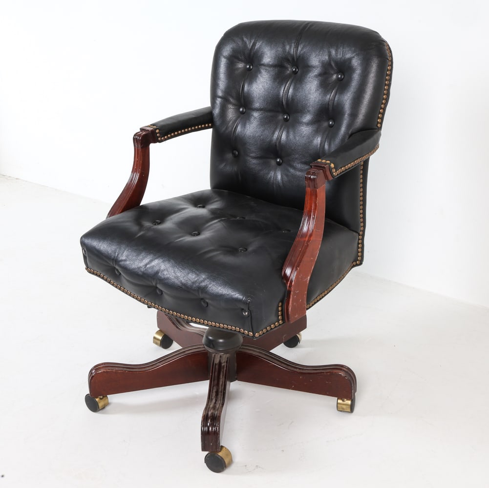 COLONY ORIGINAL LEATHER SWIVEL DESK CHAIR: Stained wood frame with black tufted leather upholstery and brass nailhead trims. Five-leg swivel base on casters. Labeled underneath. 20th century. Dimensions: H 36" x W 25" x D 26" S.H. 18".