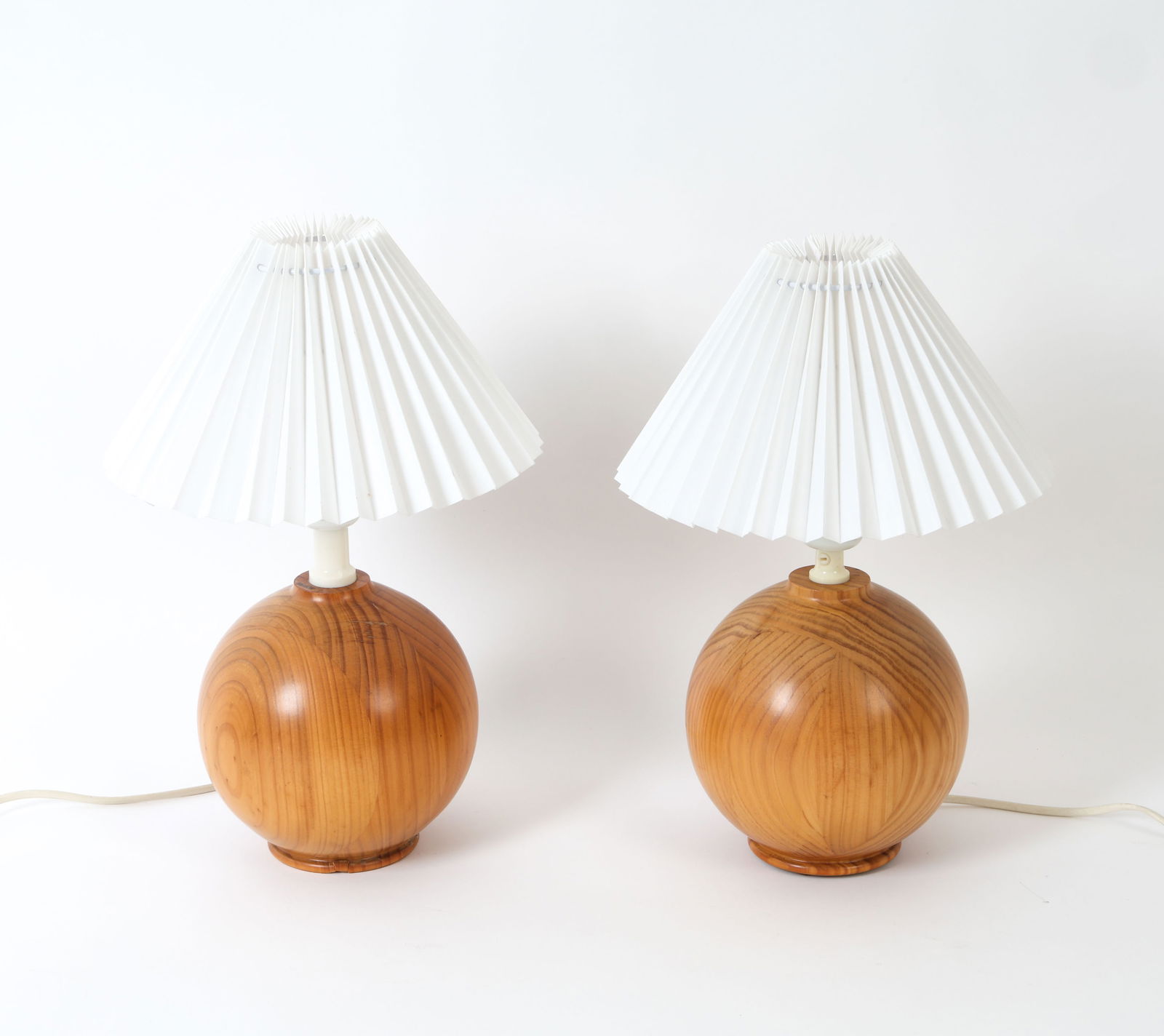 PAIR OF VINTAGE SOLID PINE SPHERE TABLE LAMPS: Round form solid pine table lamps with pleated shades. Unmarked. Dimensions: H 15" x Dia. 9.75" Condition: Not Tested, Wear consistent with age and use.