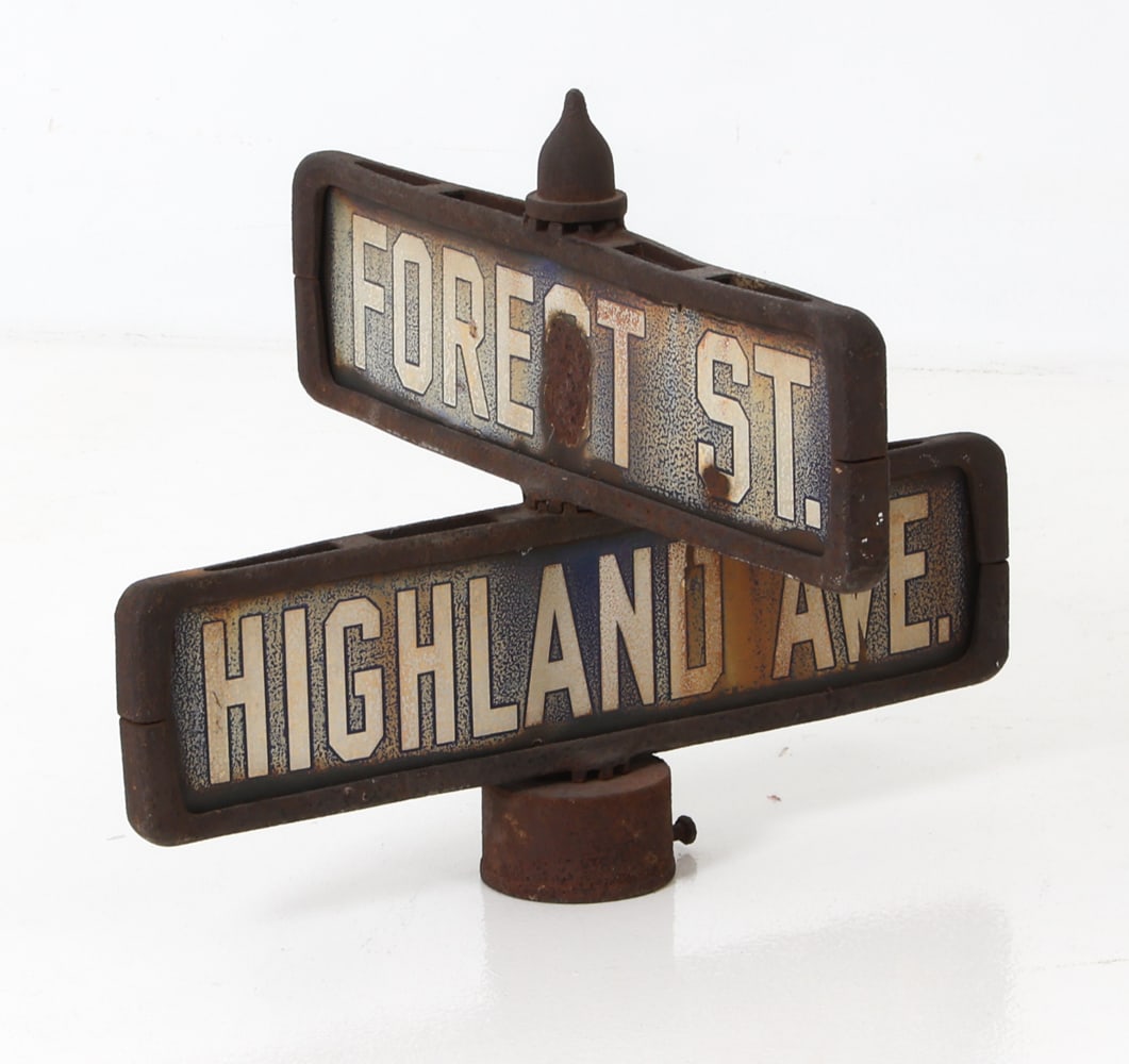 ANTIQUE ENAMEL AND IRON DOUBLE STREET SIGN: Antique metal street sign. Highland Ave and Forest street. Dimensions: H 15.25" x W 19.5" x D 19.5" Condition: Wear consistent with age and use including dings and rubs, Oxidation present. Few