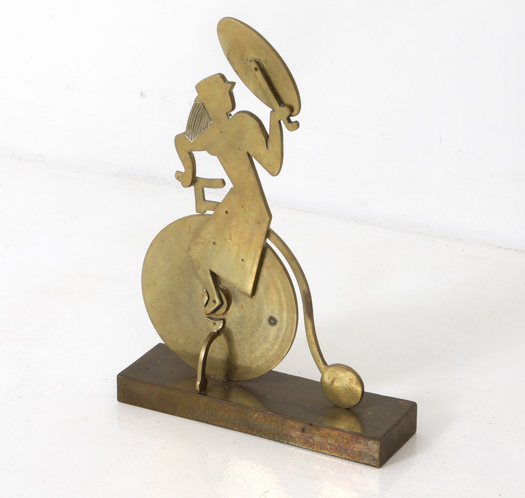 BRASS SCULPTURE OF A CYCLIST WITH UMBRELLA: 20th century Brass stylized woman riding as bicycle and holding a large umbrella. Dimensions: H 19" x W 13.5" x D 4" Condition: Wear consistent with age and use including minor rubs, scuffs, patina.