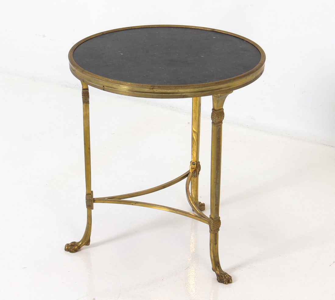 MAISON JANSEN STYLE FRENCH BRASS SIDE TABLE 1970S: French Gueridon table in gilt brass frame with a circular stone top. Fluting supports and lion feet legs. circa 1970s. Dimensions: H 18" x Dia. 16.25" Condition: Wear consistent with age and use,
