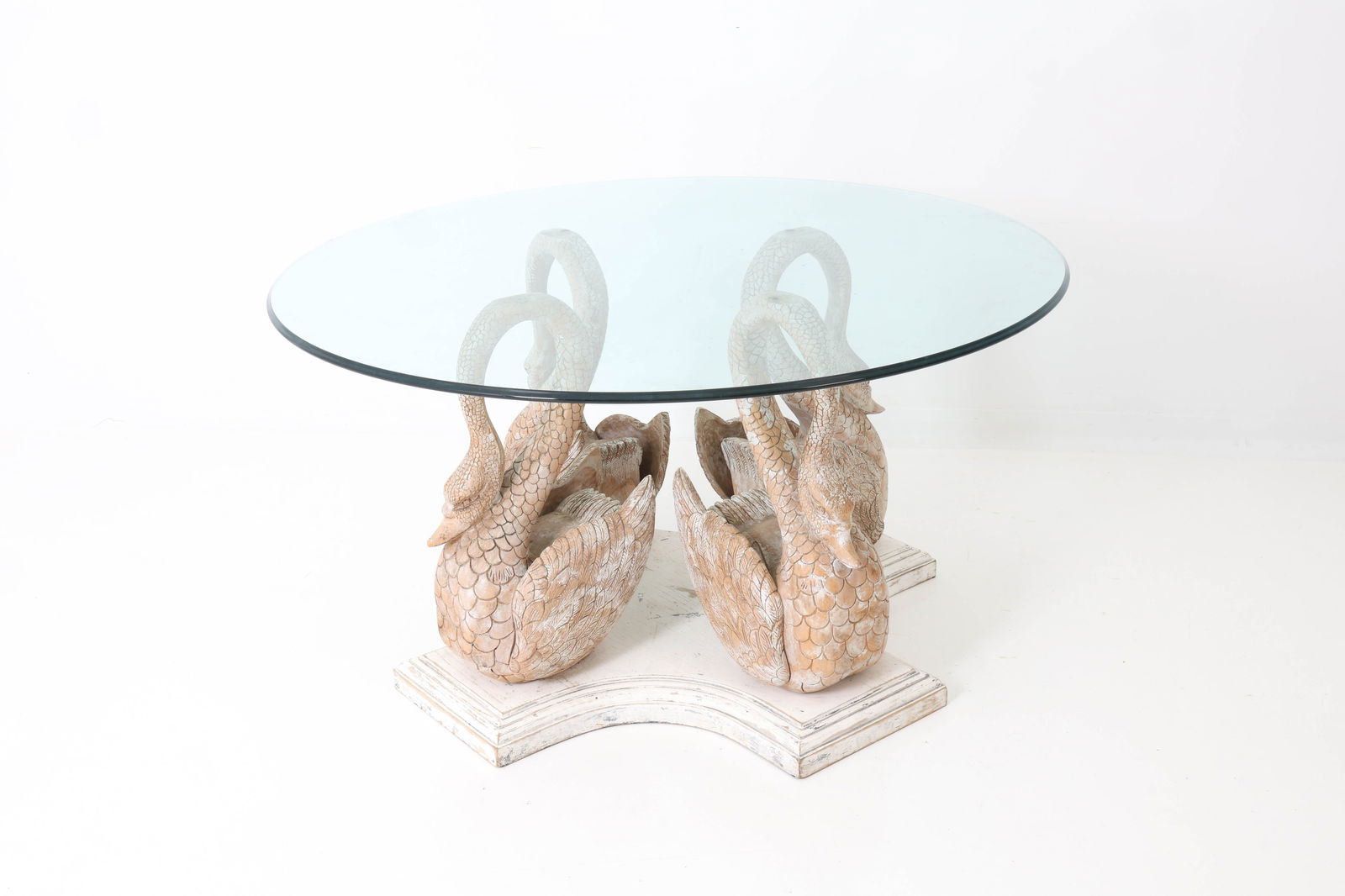20TH C. CARVED WOODEN SWAN ROUND DINING TABLE: Decorative dining table with circular glass top on a sculptural base formed by four carved swans in a radical composition. Raised on a shaped base. 20th c. Dimensions: H 29" x Dia. 54" Condition: