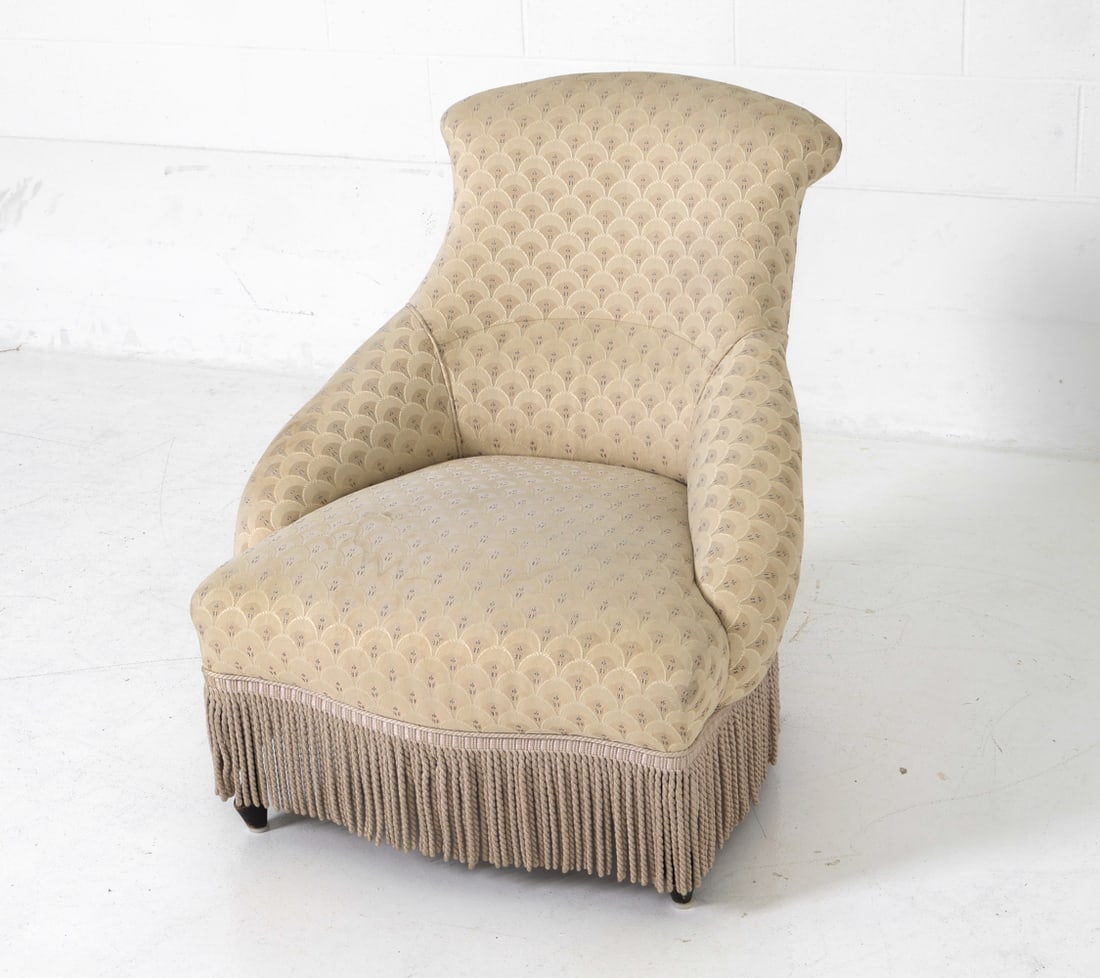 SWEDISH EMMA LOUNGE CHAIR C. 1920S: Swedish grace art deco lounge chair with oak legs, floral pattern upholstery and fringe skirt. Unmarked. Dimensions: H 31.25" x W 28" x D 29.5" x Sh 13.5" Condition: Faint spot of thinning to fabric o