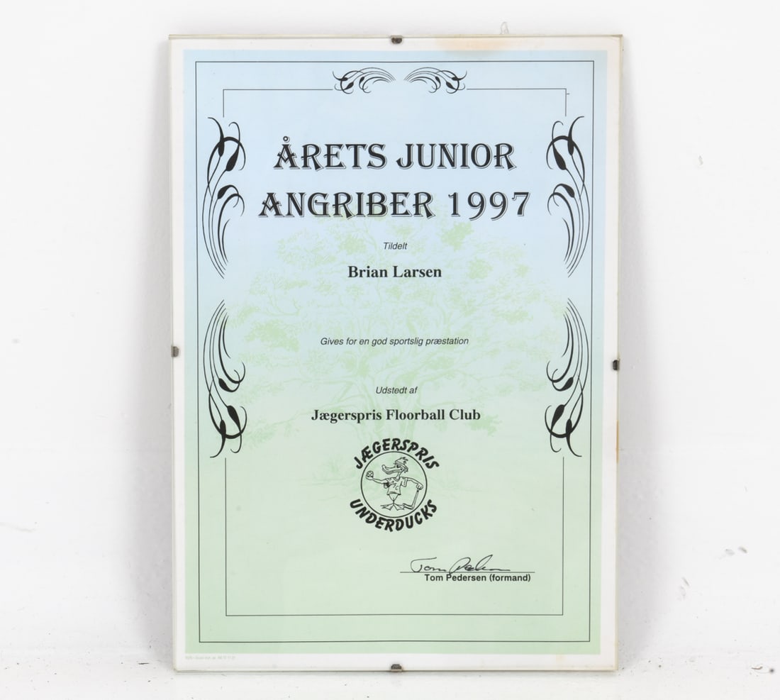 JAEGERSPRIS FLOORBALL CLUB 1997 AWARD: Junior striker of the year award from 1997 presented to a Brian Larsen, from the Jaegerspris Floorball Club. Dimensions: H 11.75" x W 8.25" Condition: Chip on glass to bottom right corner, Wear