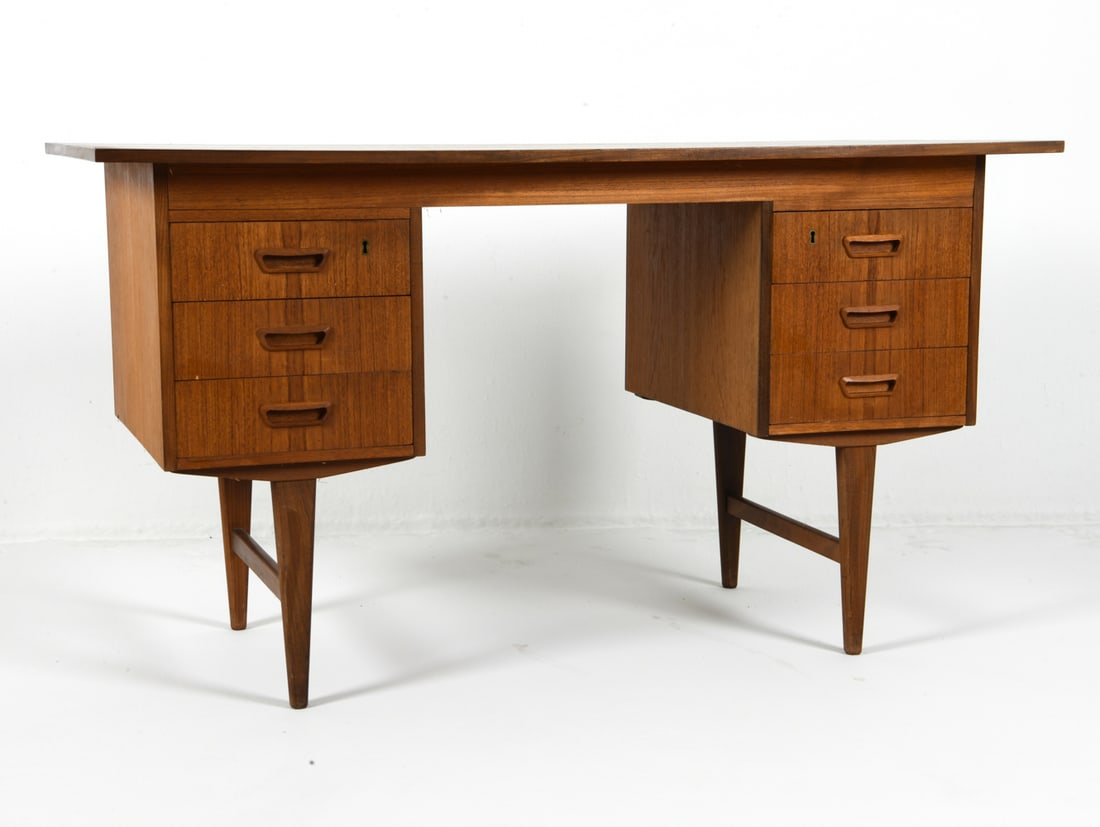 SVENSTRUP STYLE DANISH TEAK WRITING DESK C. 1960S: Key included. Teak writing desk with molded inset drawer pulls. Denmark, circa 1960s. Dimensions: H 29.25" x W 52.25" x D 25.5" Condition: Showing signs of wear consistent with age and use, including