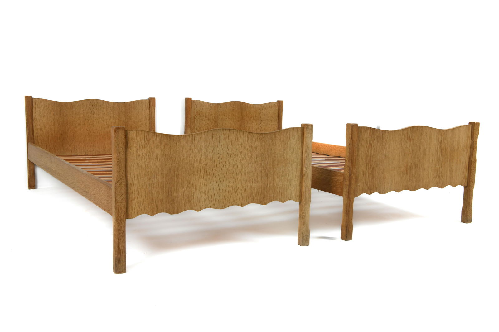 PAIR OF DANISH OAK TWIN BED FRAMES C. 1970S: (2) Oak twin-sized bed frames with scalloped ends to headboards. Denmark, circa 1970s. Dimensions: H 22" x W 36" x D 77" x SH 13". Condition: Wear consistent with age and use, including scuffs and scr