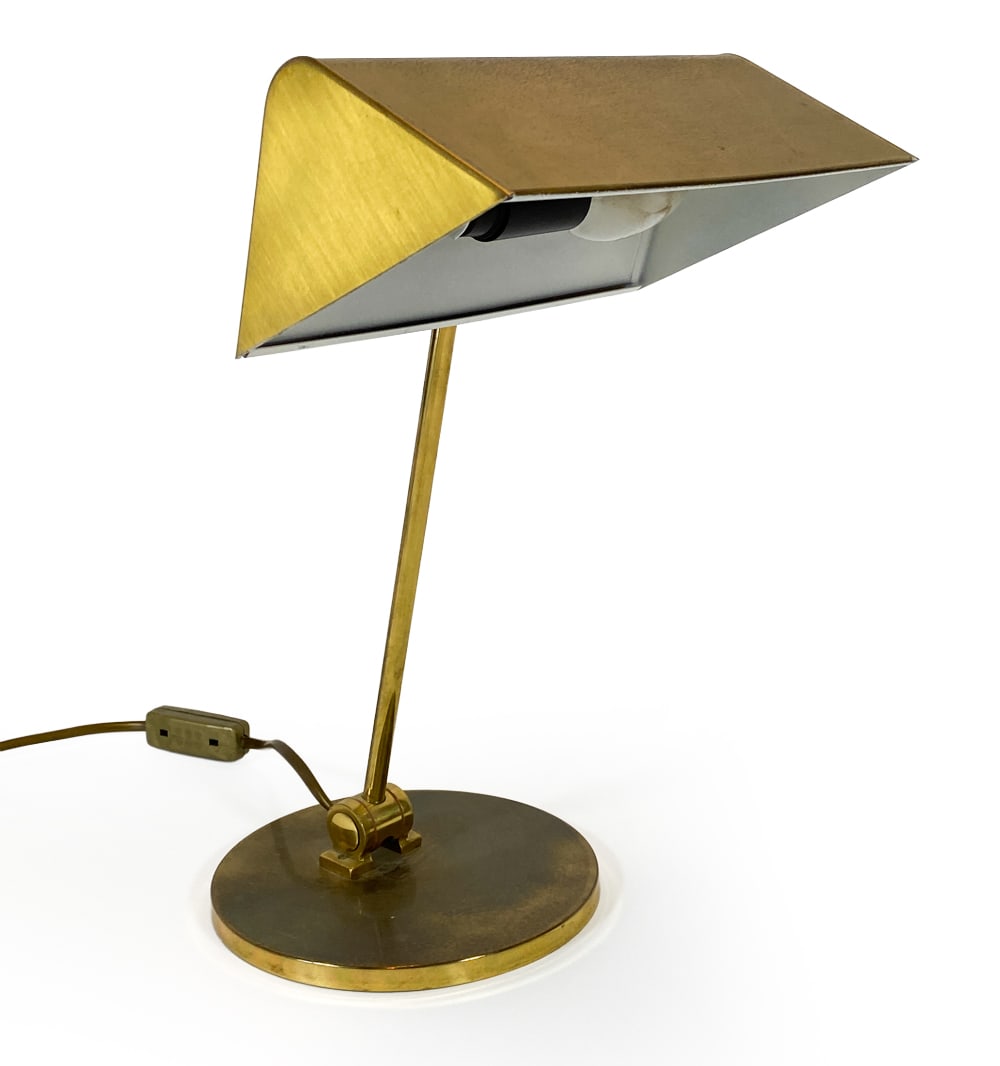 FRANDSEN DANISH BRASS TABLE LAMP C. 1970S: Desk lamp or table lamp with triangular shade and round base in brass. Tagged in shade. Denmark, circa 1970s. Dimensions: H 13" x W 9" x D 10". Condition: Wiring untested, European plug. Minor scuffs