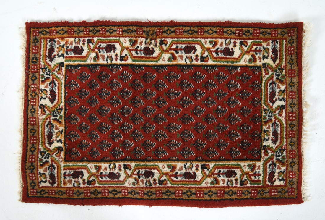 HAND-KNOTTED SAROUK MIR WOOL RUG: Hand-knotted wool rug with red field and floral patterns. Mid 20th century. Dimensions: L 39" x H 24". Condition: Signs of wear consistent with age and use. Minor losses to pile.