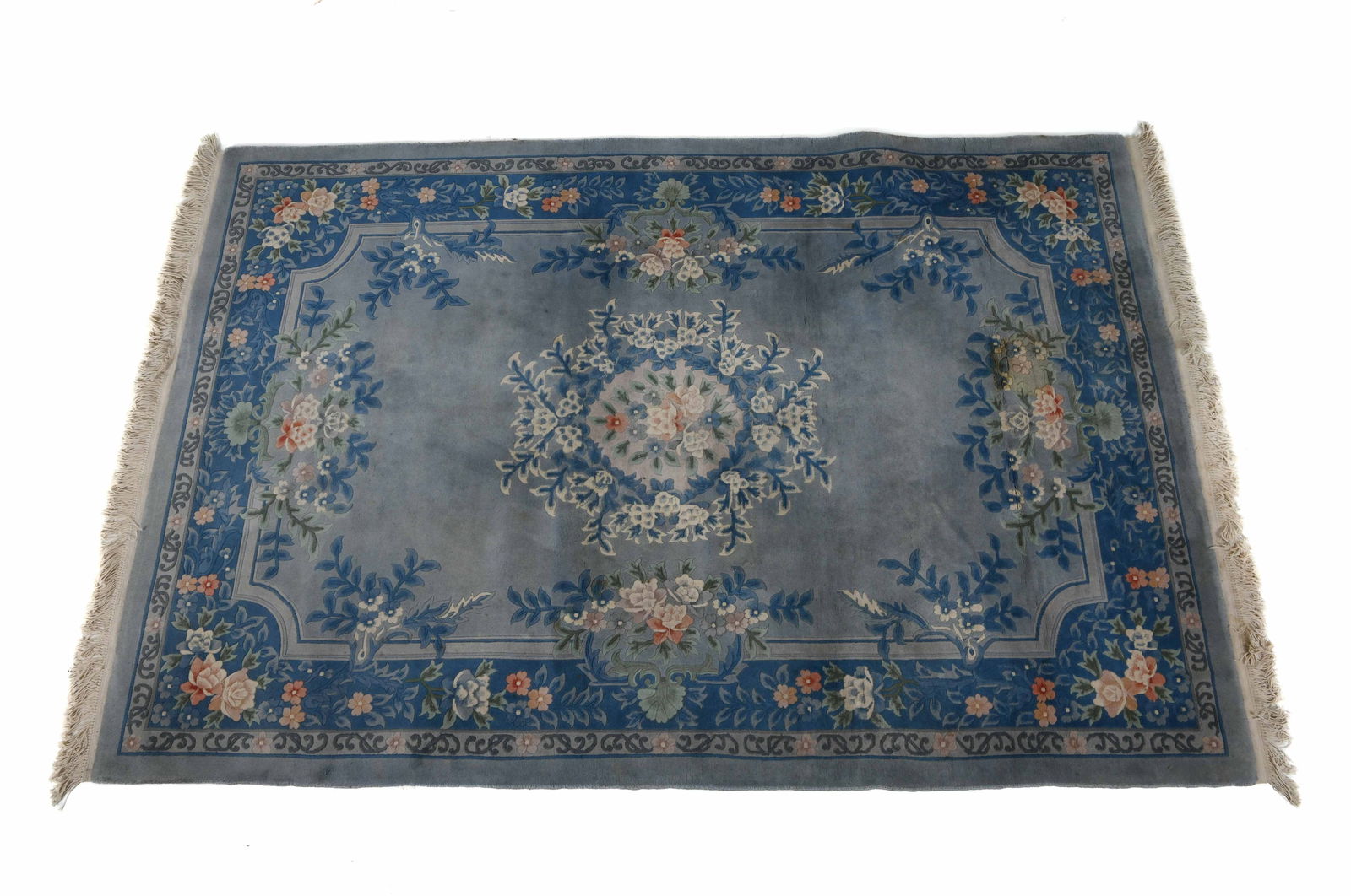 HAND-KNOTTED FLORAL PERSIAN WOOL RUG: Hand-woven wool rug in blue with floral designs. Mid 20th century. Dimensions: L 117" x W 72". Condition: Minor staining and discoloration. Wear consistent with age and use.