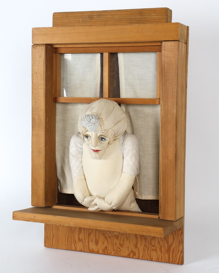 FOLK ART EMBROIDERED FIGURE IN WINDOW DISPLAY: Folk art display in wooden window. Embroidered fabric figure of an old woman. 20th century. Dimensions: H 22" x W 14" x D 7". Condition: Minor scuffs to wood. No issues to note.