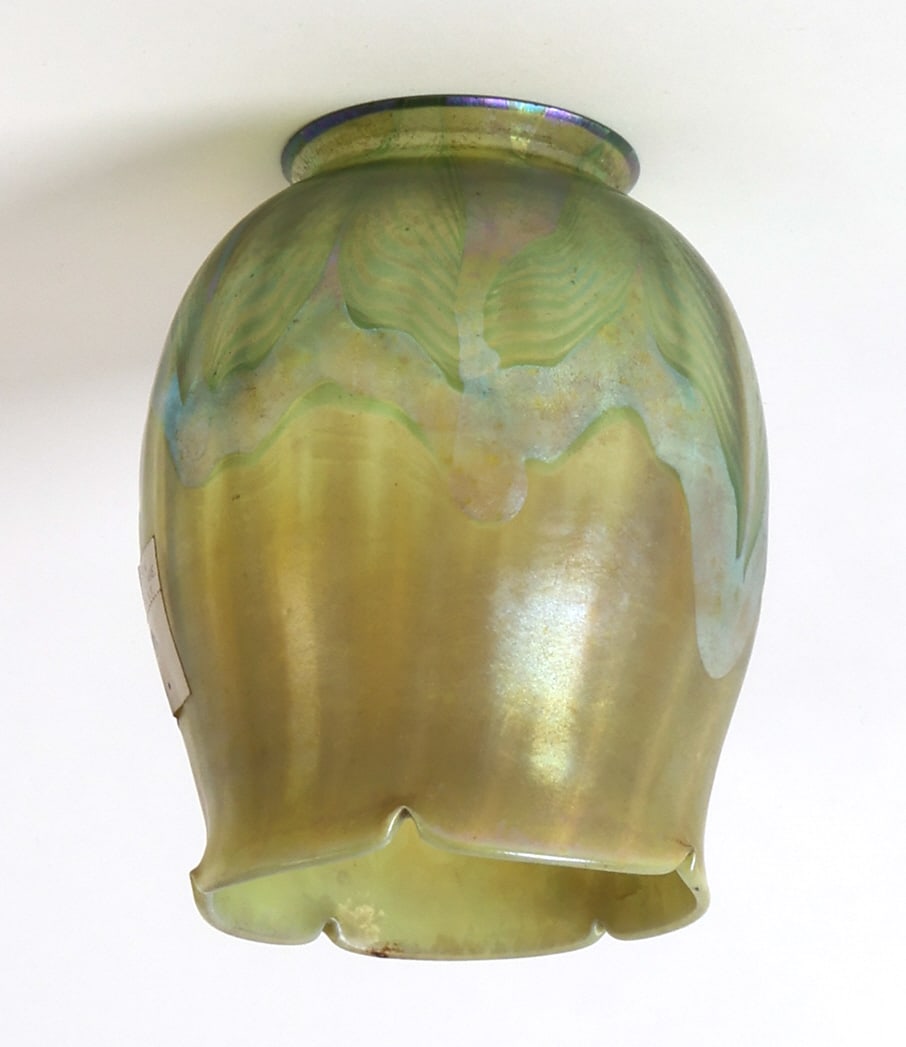 TIFFANY STUDIOS LCT FAVRILE GLASS LAMP SHADE: Green Tiffany shade with an iridescent finish, shade in the shape of a tulip. Etched on bottom rim S7013. Dimensions: H 4.5" x Dia 3.5" Provenance: From the Arthur and Joe Robinson Tiffany